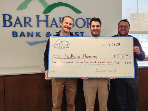 BHBT employees present a donation to Tedford Housing